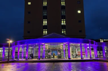 Lila angestrahlte Ansicht der Universitätsklinik Greifwald