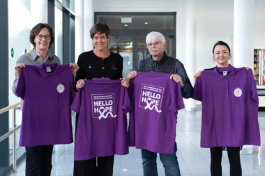 Gruppenmitglieder und Bürgermeisterin Kröger halten lila T-Shirts in der Hand